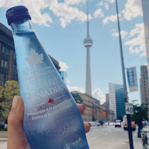 Clearly Canadian Sparkling Mineral Water Bottle 325ml Held Up With the CN Tower in the Background